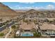A captivating aerial view of a home with a pool, landscaped grounds, and picturesque mountain views in the background at 3131 Reverence Heights Ln, Las Vegas, NV 89138