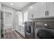 Well-organized laundry room with front load washer and dryer, cabinets, and closet at 3131 Reverence Heights Ln, Las Vegas, NV 89138