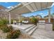 Inviting outdoor kitchen features a built-in grill and stylish seating area under a pergola at 3131 Reverence Heights Ln, Las Vegas, NV 89138