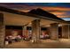 Comfortable outdoor lounge area with stylish seating, stone pillars, and cozy lighting perfect for relaxing evening socializing at 3131 Reverence Heights Ln, Las Vegas, NV 89138