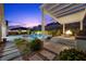 Elegant poolside retreat featuring a covered patio, a modern pool with water features, and lush landscaping at 3131 Reverence Heights Ln, Las Vegas, NV 89138