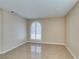Bright bedroom showcasing tile flooring and large, arched window with stylish white shutters at 3150 Soft Breezes Dr # 2030, Las Vegas, NV 89128