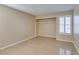 Neutral bedroom featuring tile floors, a window with shutters, and ample closet space at 3150 Soft Breezes Dr # 2030, Las Vegas, NV 89128