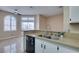 Kitchen showcasing stone countertops, a double sink, and an open view of the living area at 3150 Soft Breezes Dr # 2030, Las Vegas, NV 89128