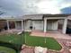 Manicured backyard featuring a putting green with a flag, covered patio, and well-maintained landscaping at 3562 Driving Range St, Las Vegas, NV 89122