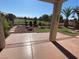 Undercover patio with landscaped backyard featuring a putting green and mature palms at 3562 Driving Range St, Las Vegas, NV 89122