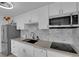 Well-lit kitchen featuring stainless steel appliances, white cabinets, and stylish backsplash at 3727 Hazelwood St # 12, Las Vegas, NV 89119