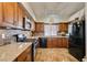 A kitchen featuring warm cabinets, granite countertops, and black appliances at 3816 Sunking St, Las Vegas, NV 89130