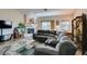 Bright living room with a fireplace, plush sofa, glass table, and large windows at 3816 Sunking St, Las Vegas, NV 89130
