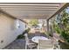 Under a louvered patio cover is an outdoor dining set and view of the backyard at 3816 Sunking St, Las Vegas, NV 89130