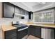 Efficient kitchen with black cabinets, modern stainless steel dishwasher, and wood-look countertop at 4339 Spencer St # 15, Las Vegas, NV 89119