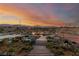 A scenic backyard features rock landscaping, a koi pond, a bridge walkway, and desert plants at sunset at 5741 N Park St, Las Vegas, NV 89149