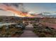 Scenic backyard at dusk with desert plants, a tranquil pond, rock details, and a walking bridge at 5741 N Park St, Las Vegas, NV 89149