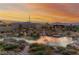 Picturesque backyard boasts a lush pond, decorative rocks, and a wooden bridge set against a colorful twilight sky at 5741 N Park St, Las Vegas, NV 89149