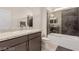 Bathroom featuring a modern vanity with granite countertop, a sleek sink, and a shower-tub combination with glass door at 5741 N Park St, Las Vegas, NV 89149