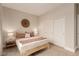 Bright bedroom features a bed with neutral bedding, a woven wall decoration, and a built-in closet with white doors at 5741 N Park St, Las Vegas, NV 89149