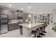 Open kitchen features gray cabinets, granite counters, island with seating, and stainless appliances at 5741 N Park St, Las Vegas, NV 89149