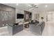 Modern living room with stylish gray furniture, decorative wall art, and a ceiling fan at 5741 N Park St, Las Vegas, NV 89149