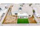 Rear aerial view of the house showcasing artificial grass, desert landscaping, and a covered patio at 6124 Desert Haven Rd, Las Vegas, NV 89130