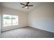Bedroom with neutral carpet and baseboards, white paint, and a large window at 6124 Desert Haven Rd, Las Vegas, NV 89130