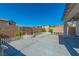 Spacious backyard with a concrete patio, partial shade, and a small garden area with a white fence at 6442 Kobe Knoll Ct, Las Vegas, NV 89141