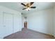 This bedroom features neutral walls, carpeted floors, a ceiling fan, and a closet with double doors at 6442 Kobe Knoll Ct, Las Vegas, NV 89141