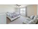Bright bedroom with a bed, sofa, large window with curtains, and neutral carpet flooring at 6442 Kobe Knoll Ct, Las Vegas, NV 89141
