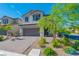 Traditional two-story home with lush front yard landscaping and a brick driveway to a two-car garage at 6442 Kobe Knoll Ct, Las Vegas, NV 89141