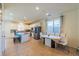 Modern kitchen with stainless appliances, island with seating, and an adjacent dining area with large windows at 6442 Kobe Knoll Ct, Las Vegas, NV 89141