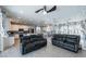 Open concept living room and kitchen featuring tile floors, ceiling fan and black leather sofas at 6442 Kobe Knoll Ct, Las Vegas, NV 89141