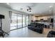 Bright living room with tile floors, sliding glass doors to the patio and view into the kitchen at 6442 Kobe Knoll Ct, Las Vegas, NV 89141