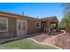 View of the side yard and backyard featuring an outdoor covered area with desert landscaping and rock ground covering at 653 Paloma Cir, Mesquite, NV 89027