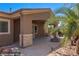View of the covered backyard patio with ceiling fans, a stone fire pit, and beautiful desert landscaping at 653 Paloma Cir, Mesquite, NV 89027