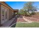 View of the side yard and backyard featuring an outdoor covered area with desert landscaping and rock ground covering at 653 Paloma Cir, Mesquite, NV 89027
