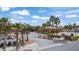 Stunning desert community clubhouse with mature palm trees, tidy landscaping, and ample golf cart parking on a sunny day at 653 Paloma Cir, Mesquite, NV 89027