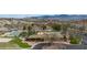 A beautiful community clubhouse, pool, and tennis courts are shown in an aerial view surrounded by mountains and desert landscaping at 653 Paloma Cir, Mesquite, NV 89027