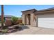 Inviting front entrance featuring stone archway, potted plants, and lush landscaping at 653 Paloma Cir, Mesquite, NV 89027
