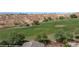 Backyard golf course featuring lush green grass, mature trees, and sand trap at 653 Paloma Cir, Mesquite, NV 89027