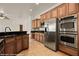 Modern kitchen with stainless steel appliances, wooden cabinets, and tiled backsplash at 653 Paloma Cir, Mesquite, NV 89027