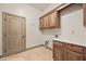Laundry room with wooden cabinets and tile flooring at 653 Paloma Cir, Mesquite, NV 89027