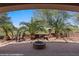 Covered patio featuring a built-in fire pit, palm trees, and views of the golf course at 653 Paloma Cir, Mesquite, NV 89027