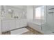 Bright bathroom featuring a double vanity, soaking tub with shower, and white cabinets at 6854 Chargehand Ave, Las Vegas, NV 89156
