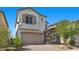 Beautiful two-story home with a brick driveway, tan stucco, stone facade, and a two-car garage at 6854 Chargehand Ave, Las Vegas, NV 89156
