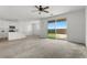 Open living room and kitchen concept offering bright natural light with neutral carpeting and paint at 6854 Chargehand Ave, Las Vegas, NV 89156