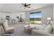 Bright open-concept living room featuring modern furnishings, neutral tones, and sliding glass doors to the backyard at 6854 Chargehand Ave, Las Vegas, NV 89156
