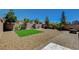 Spacious backyard features decorative rock, artificial grass, paved patio, and lush trees at 7246 Dazzle Point St, North Las Vegas, NV 89084