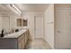 Bright bathroom with double vanity, granite counters, tiled floors, and ample storage at 7246 Dazzle Point St, North Las Vegas, NV 89084