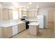 Well-lit kitchen with white appliances, light wood cabinets, and an island at 7570 Durham Hall Ave # 101, Las Vegas, NV 89130