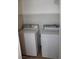 Bright laundry area features a white washer and dryer set with shelving for storage at 7570 Durham Hall Ave # 101, Las Vegas, NV 89130