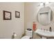 Charming half bathroom with pedestal sink, decorative art, and neutral color scheme at 8104 Wispy Sage Way, Las Vegas, NV 89149